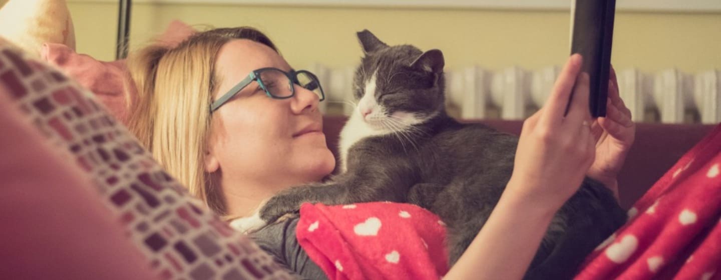 femme lisant le livre avec son chat la nuit