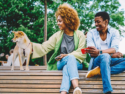 Femme et homme assis sur un banc avec un chien