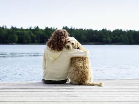 Une femme avec un chien près du lac