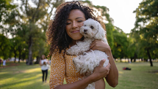 femme avec un chien blanc à l'extérieur